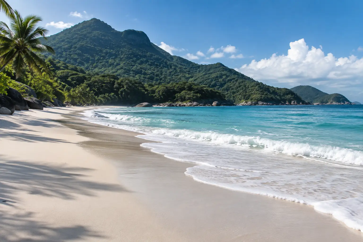 Playa larga de arena blanca con olas y un cerro cubierto de selva